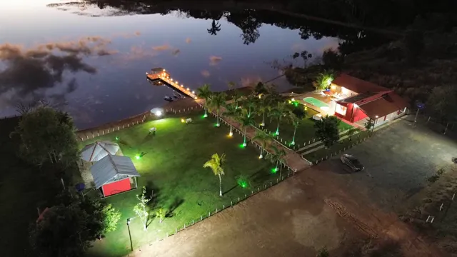 A chácara iluminada e o lago vistos do alto ao anoitecer