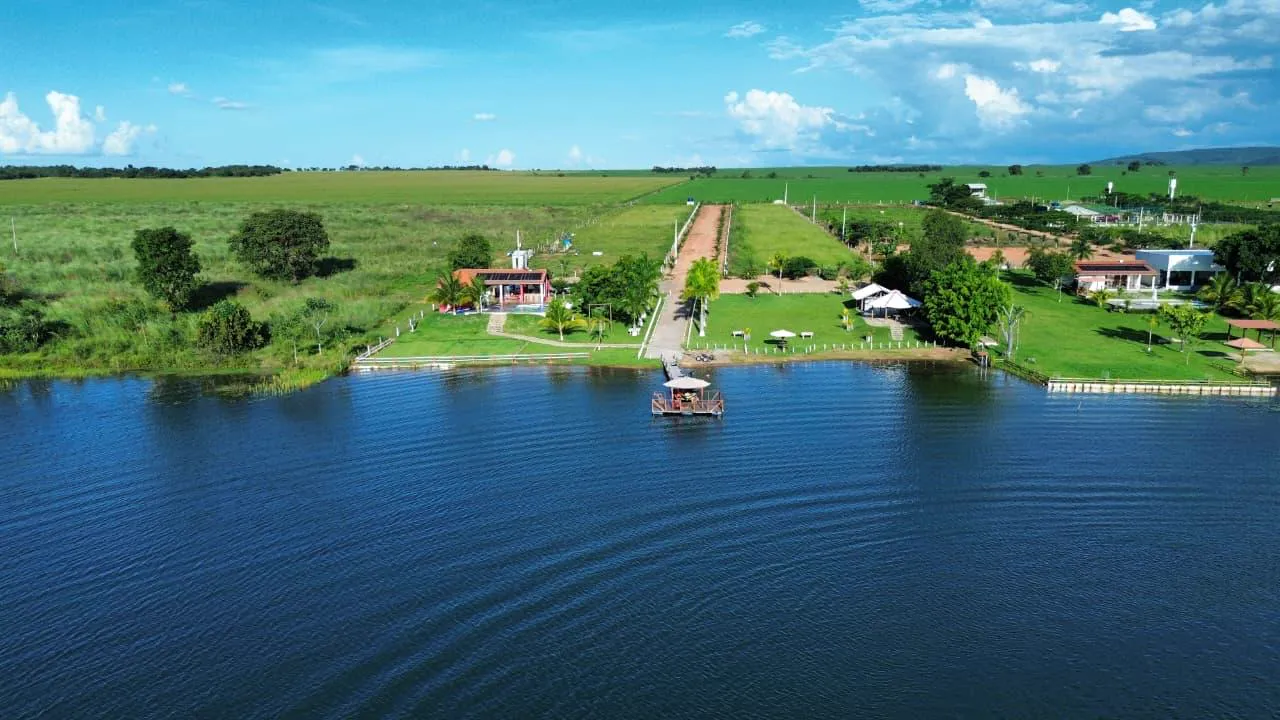 Vista aérea da Chácara Vitória, com píer, jardins e casa às margens do lago