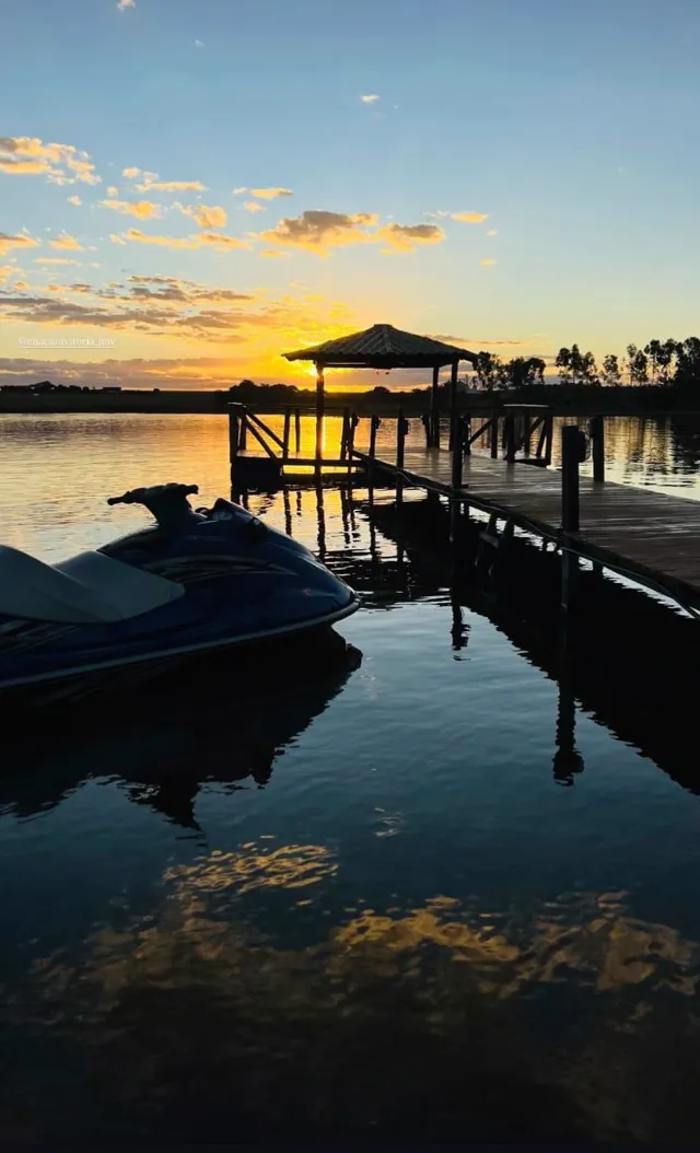 A silhueta do píer e seus reflexos no lago ao entardecer